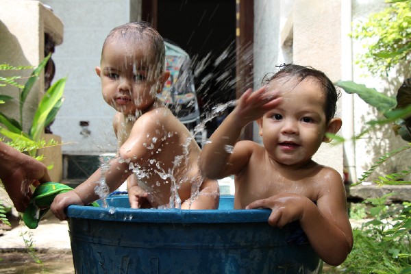 Our boys splish splashing in a plastic tub outside